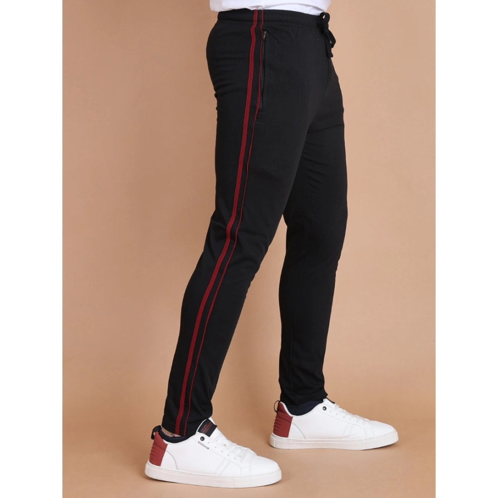Black pants with red stripes worn by a person on a beige background