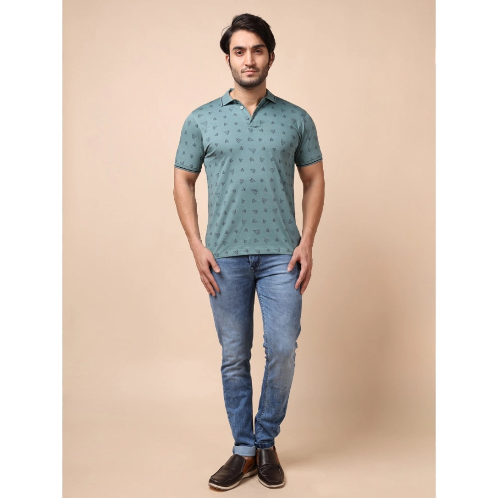 Man wearing a patterned green shirt and blue jeans on a beige background