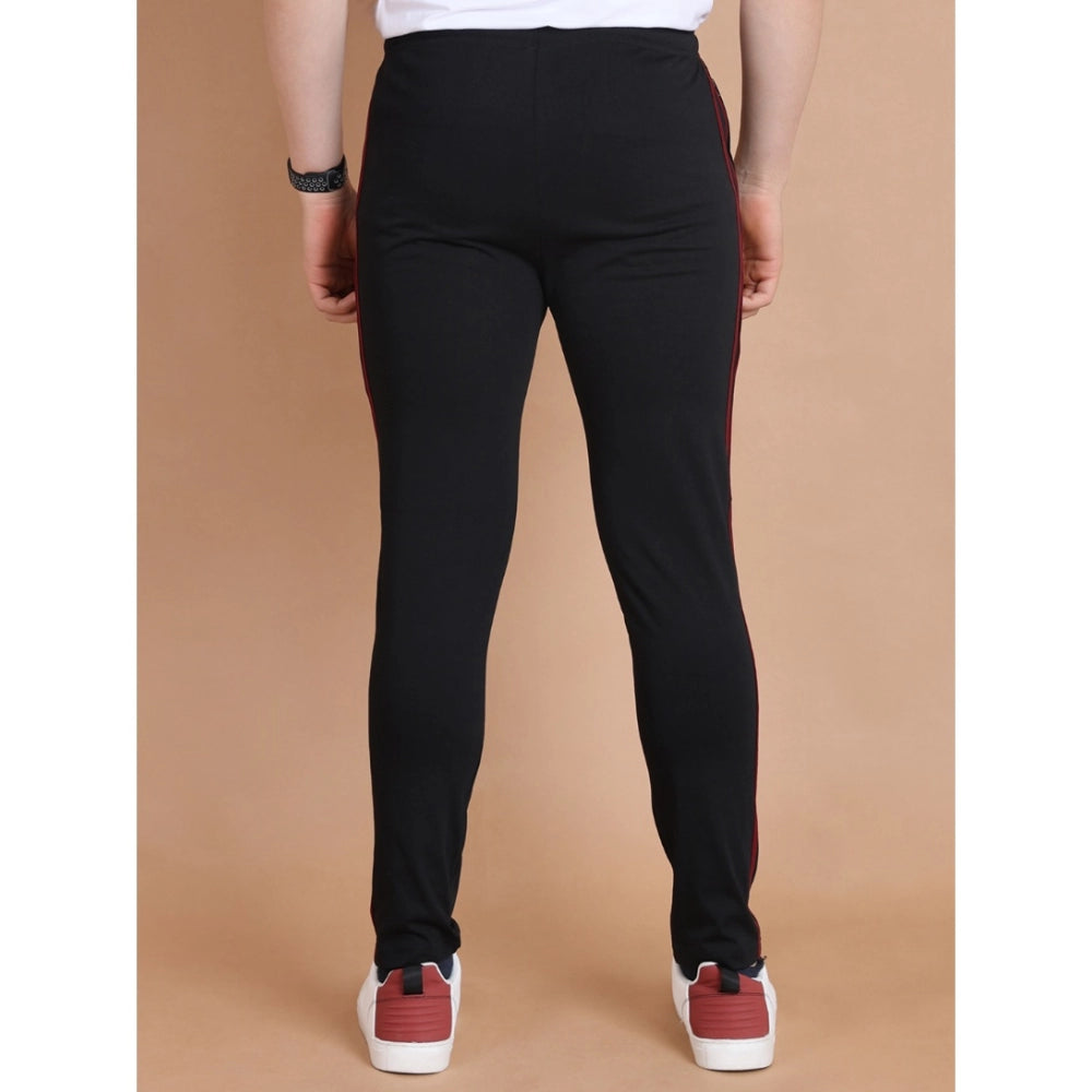 Person wearing black pants and red shoes on a beige background