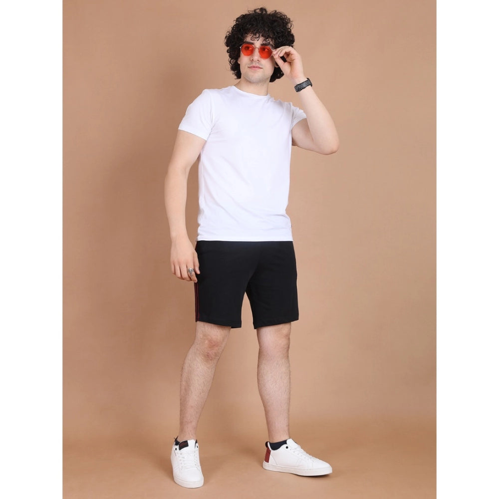 Man wearing a white t-shirt, black shorts, and white sneakers 
