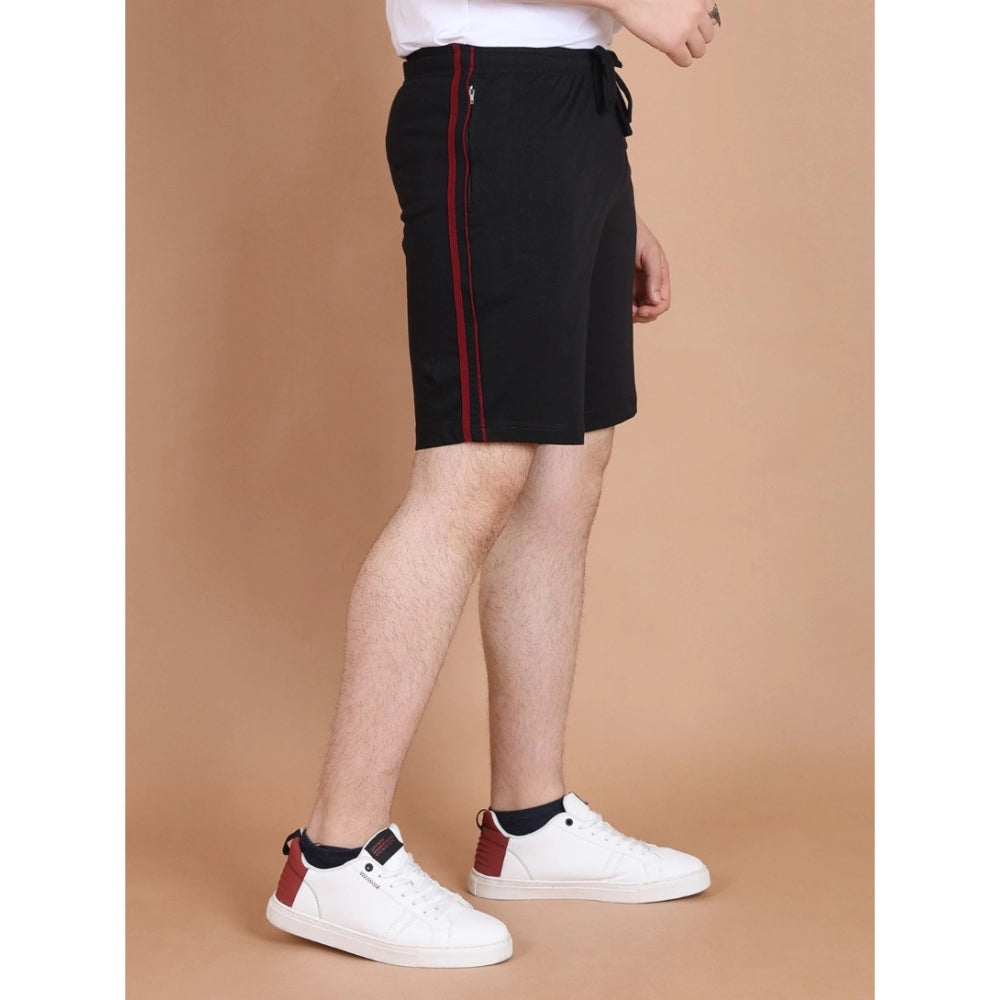 Person wearing black shorts with a red stripe on a beige background