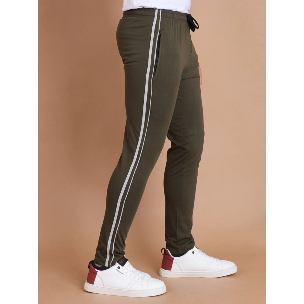 Green jogger pants with white stripes on a brown background