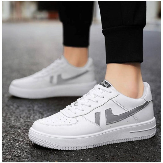 White sneakers with gray accents worn on a street.