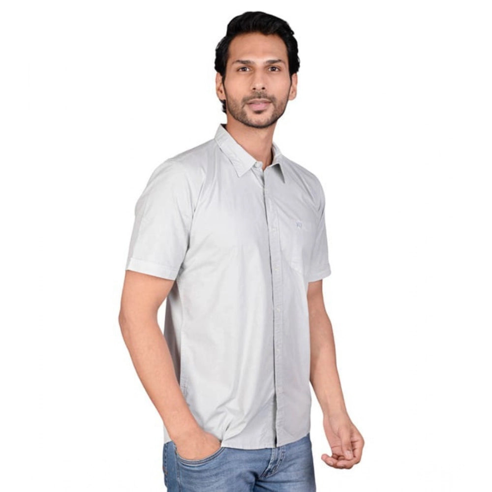 Man wearing a light gray short-sleeve shirt on a white background