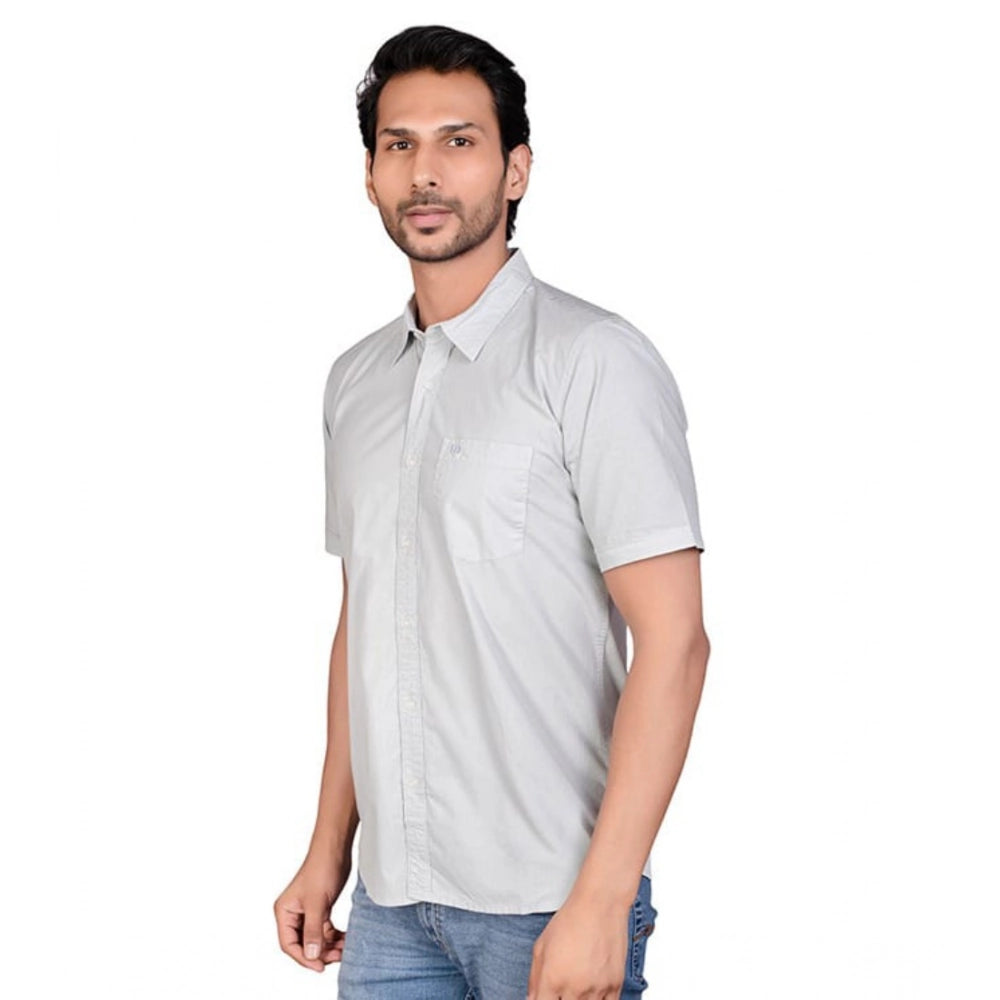 Man wearing a light gray short-sleeve shirt on a white background