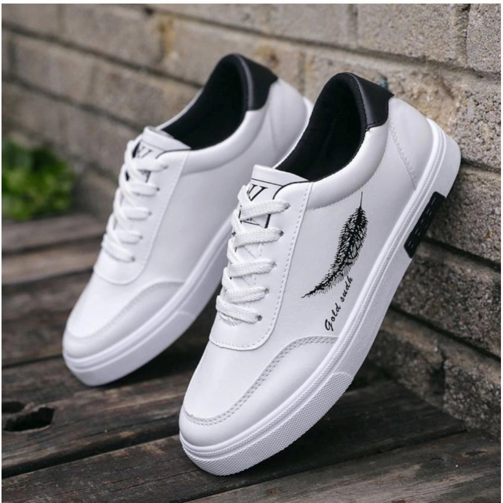 White sneakers with black feather design on a wooden surface against a brick wall.
